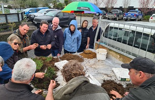 image of farmers looking at soils
