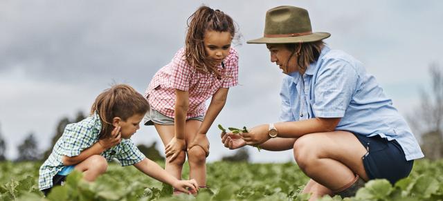 image of female farmer in field with children