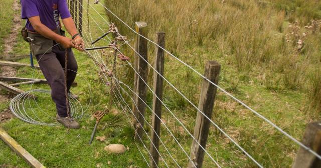 image of farmer fixing fence
