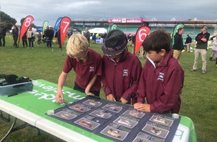 image of three students looking at pictures at field day