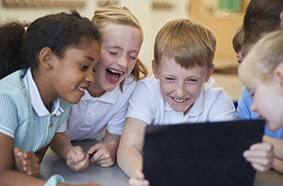 image of school students around laptop laughing
