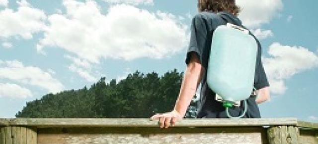 student leaning on fence