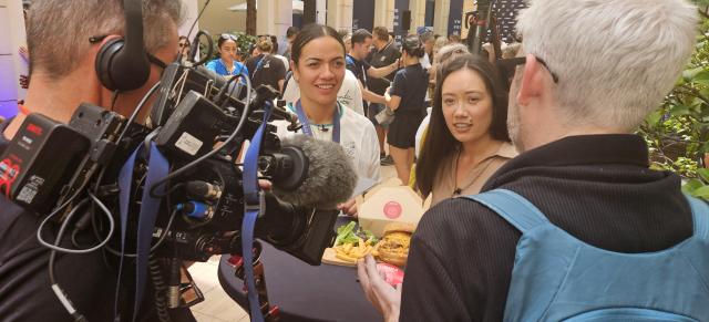 image of athletes and media at Paris Olympics