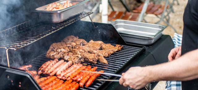 image of person barbecuing steak and sausages on outside grill