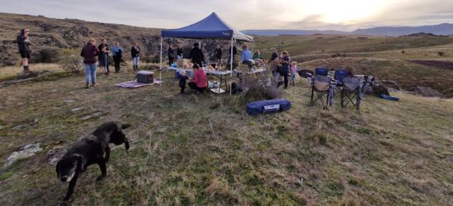 image of catchment group under blue tent. Dog in foreground. 