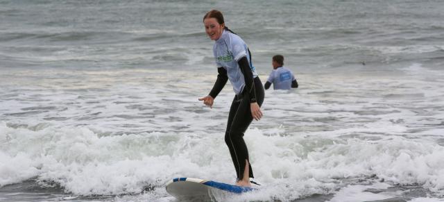 image of girl surfing in branded B+LNZ top