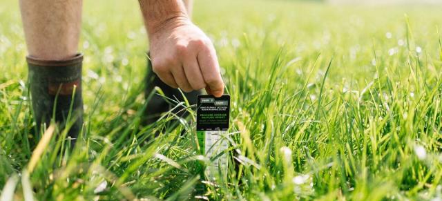 Image of male farmer using B+LNZ sward stick to test pasture