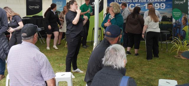 image of people talking and sitting in field day tent
