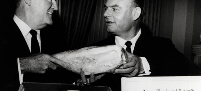 black and white image of two men holding leg of lamb