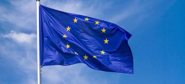European Union flag blowing in wind with blue sky