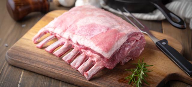 image of fresh lamb rack on cutting board next to knife