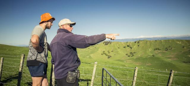 image of two farmers looking at land