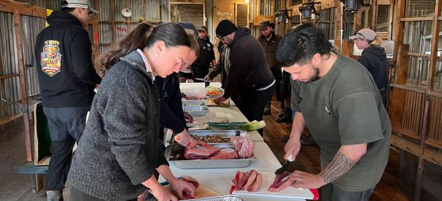 Image of farmers cutting and preparing meat for event