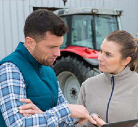 image of two farmers discussing reports