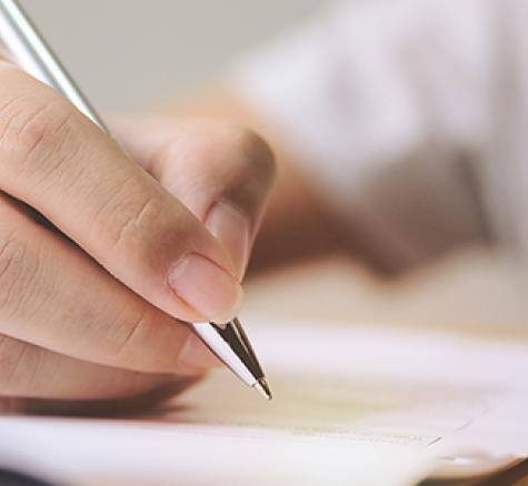 image of person with pen filling out form