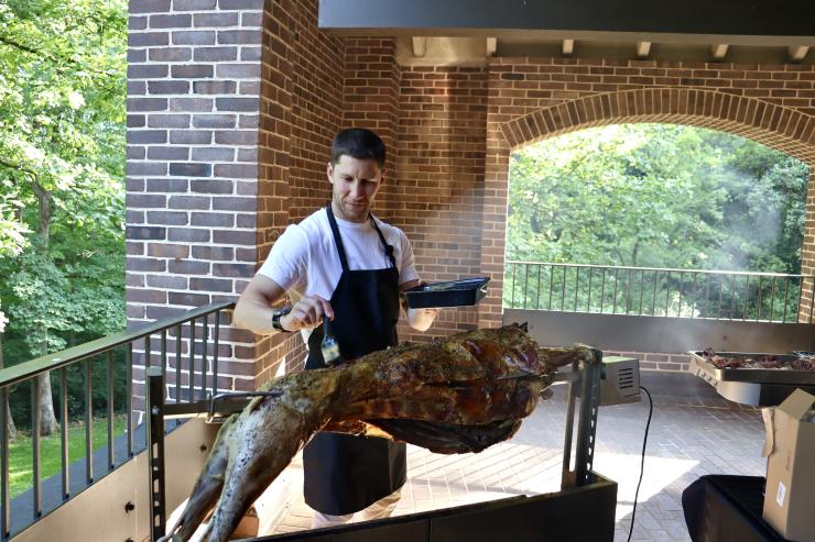image of chef infront of lamb on spitt