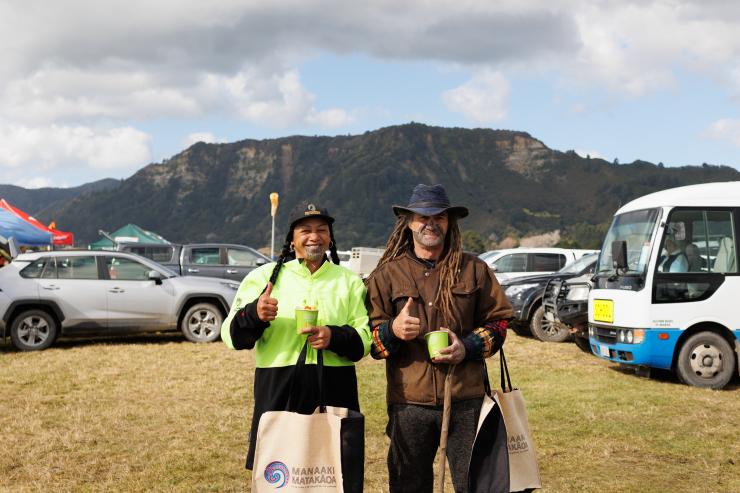 image of two people at field day infront of vehciles
