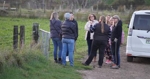 image of team listening to host on farm tour