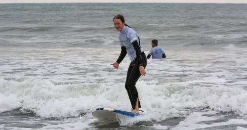 image of girl surfing in branded B+LNZ top