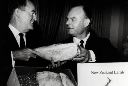 black and white image of two men holding leg of lamb