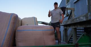 image of young farmer by woolshed
