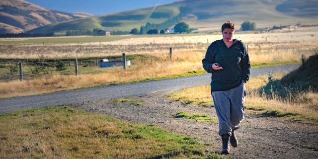 header image of girl on phone while walking on farm