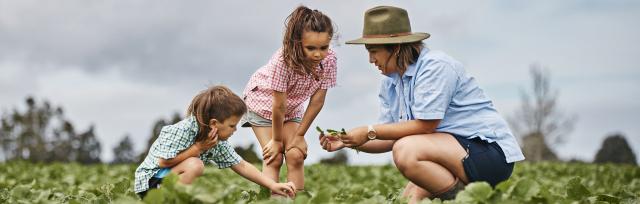 image of female farmer in field with children