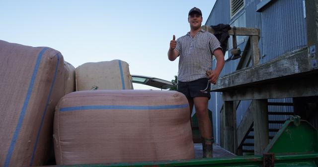 image of young farmer by woolshed