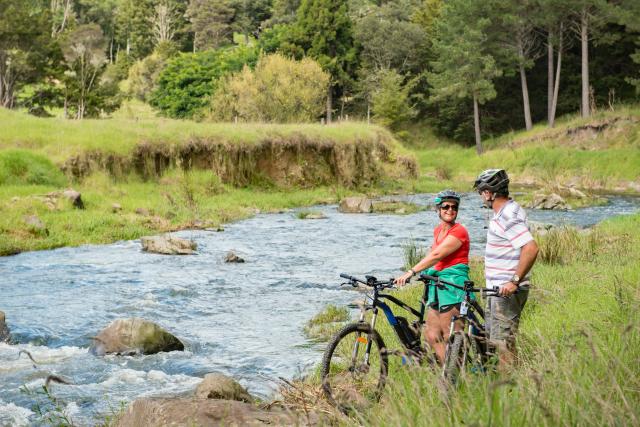 image of couple cycling next to river