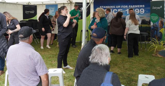 image of people talking and sitting in field day tent