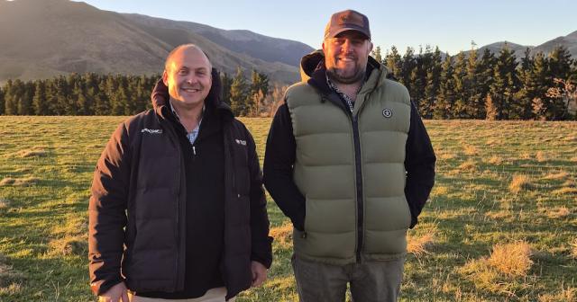 image of two male farmers standing infront of paddock