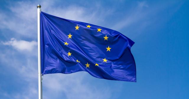 European Union flag blowing in wind with blue sky