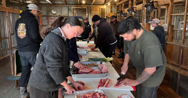 Image of farmers cutting and preparing meat for event